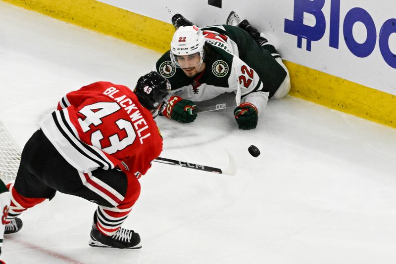 Apr 7, 2024; Chicago, Illinois, USA;  Chicago Blackhawks center Colin Blackwell (43) passes the puck away from Minnesota Wild center Marat Khusnutdinov (22) during the third period at United Center. Mandatory Credit: Matt Marton-USA TODAY Sports