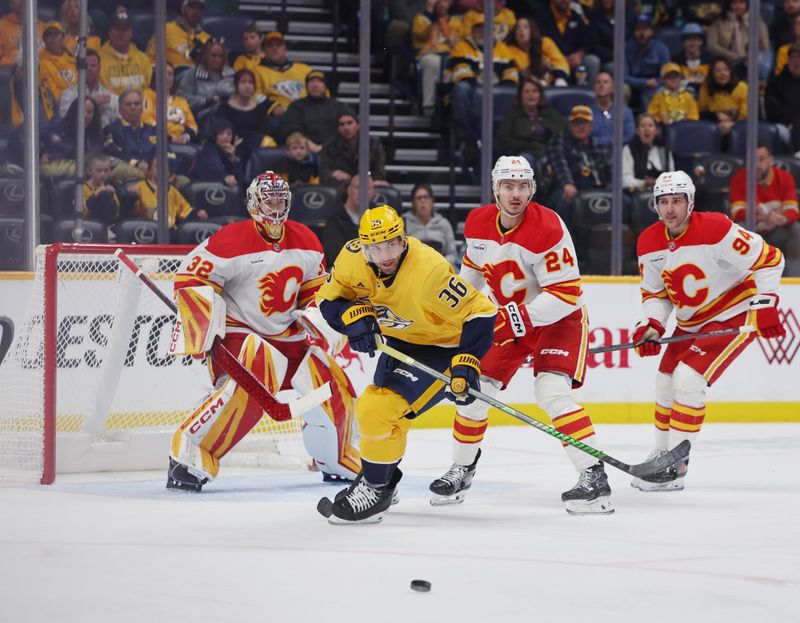 Nov 1, 2025; Nashville, Tennessee, USA; Nashville Predators left wing Cole Smith (36) plays the puck against Calgary Flames goaltender Dustin Wolf (32), defenseman Jake Bean (24) and defenseman Brayden Pachal (94) during the first period at Bridgestone Arena. Mandatory Credit: Alan Poizner-Imagn Images