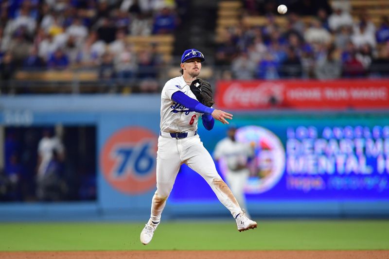 Jun 12, 2024; Los Angeles, California, USA; Los Angeles Dodgers third baseman Cavan Biggio (6) throws to first for the out against Texas Rangers second baseman Marcus Semien (2) during the ninth inning at Dodger Stadium. Mandatory Credit: Gary A. Vasquez-USA TODAY Sports