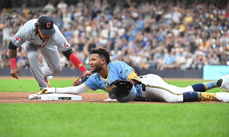 Aug 16, 2024; Milwaukee, Wisconsin, USA; Milwaukee Brewers outfielder Jackson Chourio (11) slides into third base ahead of the tag by Cleveland Guardians third base José Ramírez (11) for a triple in the first inning  at American Family Field. Mandatory Credit: Michael McLoone-USA TODAY Sports