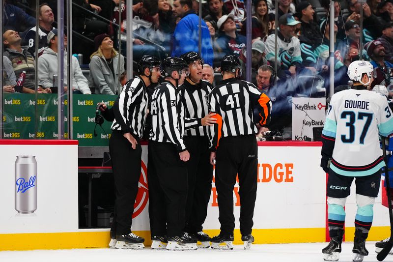 Nov 5, 2024; Denver, Colorado, USA; NHL referees gather for a goal review in the second period between the Seattle Kraken against the Colorado Avalanche at Ball Arena. Mandatory Credit: Ron Chenoy-Imagn Images