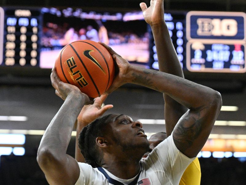 Mar 10, 2024; Iowa City, Iowa, USA; Illinois Fighting Illini forward Dain Dainja (42) goes to the basket as Iowa Hawkeyes forward Ladji Dembele (13) defends during the first half at Carver-Hawkeye Arena. Mandatory Credit: Jeffrey Becker-USA TODAY Sports