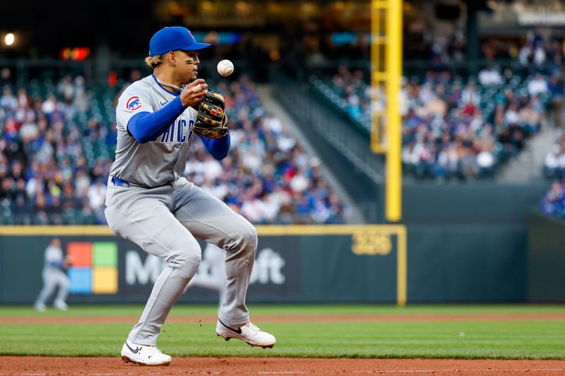 Apr 12, 2024; Seattle, Washington, USA; Chicago Cubs third baseman Christopher Morel (5) mishandles the transfer before a throw against the Seattle Mariners during the third inning at T-Mobile Park. The play was ruled a hit. Mandatory Credit: Joe Nicholson-USA TODAY Sports