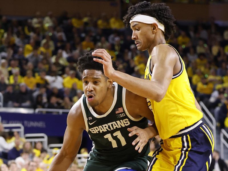 Feb 18, 2023; Ann Arbor, Michigan, USA;  Michigan State Spartans guard A.J. Hoggard (11) dribbles the ball against Michigan Wolverines guard Kobe Bufkin (2) in the second half at Crisler Center. Mandatory Credit: Rick Osentoski-USA TODAY Sports