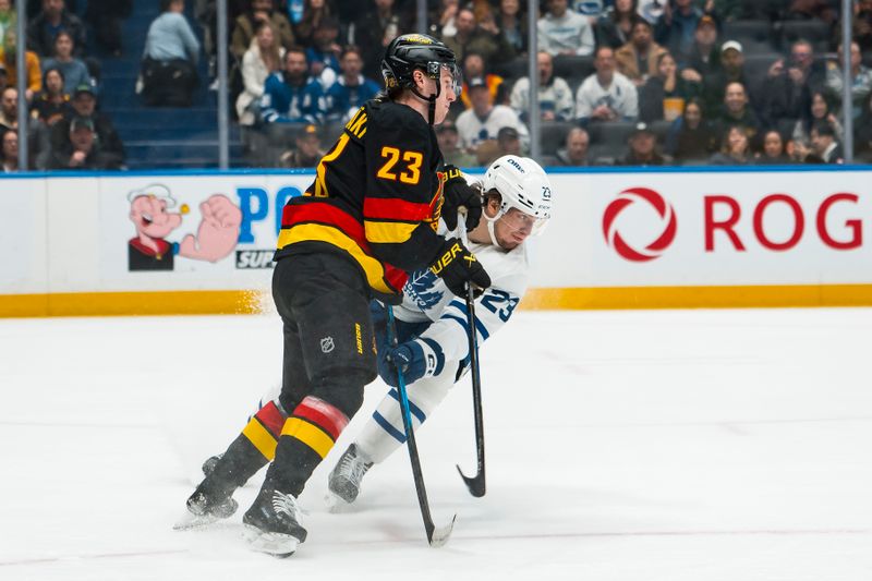 Jan 31, 2026; Vancouver, British Columbia, CAN; Toronto Maple Leafs forward Matthew Knies (23) checks Vancouver Canucks forward Jonathan Lekkerimaki (23) in the second period at Rogers Arena. Mandatory Credit: Bob Frid-Imagn Images