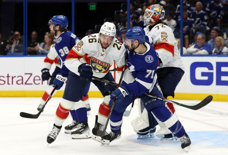 Apr 22, 2025; Tampa, Florida, USA; Florida Panthers defenseman Uvis Balinskis (26) and Tampa Bay Lightning center Anthony Cirelli (71) defend during the first period in game one of the first round of the 2025 Stanley Cup Playoffs at Amalie Arena. Mandatory Credit: Kim Klement Neitzel-Imagn Images