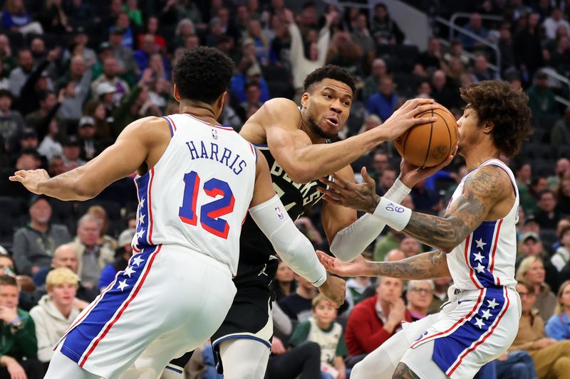 MILWAUKEE, WISCONSIN - MARCH 14: Giannis Antetokounmpo #34 of the Milwaukee Bucks drives between Tobias Harris #12 and Kelly Oubre Jr. #9 of the Philadelphia 76ers during the first half of a game at Fiserv Forum on March 14, 2024 in Milwaukee, Wisconsin. NOTE TO USER: User expressly acknowledges and agrees that, by downloading and or using this photograph, User is consenting to the terms and conditions of the Getty Images License Agreement. (Photo by Stacy Revere/Getty Images)