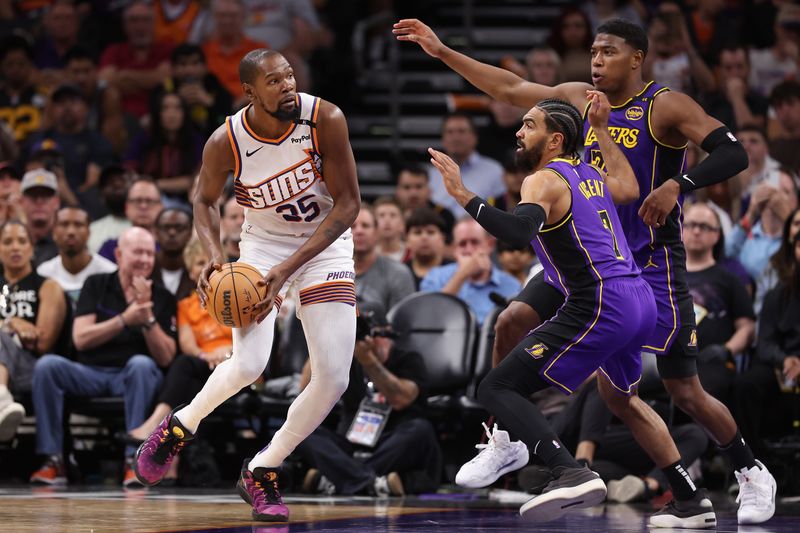 PHOENIX, ARIZONA - OCTOBER 28: Kevin Durant #35 of the Phoenix Suns handles the ball under pressure from Gabe Vincent #7 and Rui Hachimura #28 of the Los Angeles Lakers during the second half of the NBA game at Footprint Center on October 28, 2024 in Phoenix, Arizona.  The Suns defeated the Lakers 109-105. NOTE TO USER: User expressly acknowledges and agrees that, by downloading and/or using this photograph, user is consenting to the terms and conditions of the Getty Images License Agreement. (Photo by Christian Petersen/Getty Images)