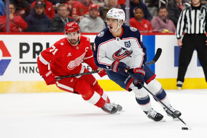 Nov 22, 2025; Detroit, Michigan, USA;  Columbus Blue Jackets center Cole Sillinger (4) skates with the puck defended by Detroit Red Wings center Dylan Larkin (71) in the first period at Little Caesars Arena. Mandatory Credit: Rick Osentoski-Imagn Images