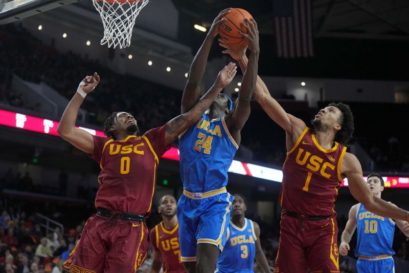 Jan 27, 2025; Los Angeles, California, USA; UCLA Bruins forward William Kyle III (24) battles for the ball with Southern California Trojans forward Saint Thomas (0) and guard Desmond Claude (1) in the first half at Galen Center. Mandatory Credit: Kirby Lee-Imagn Images