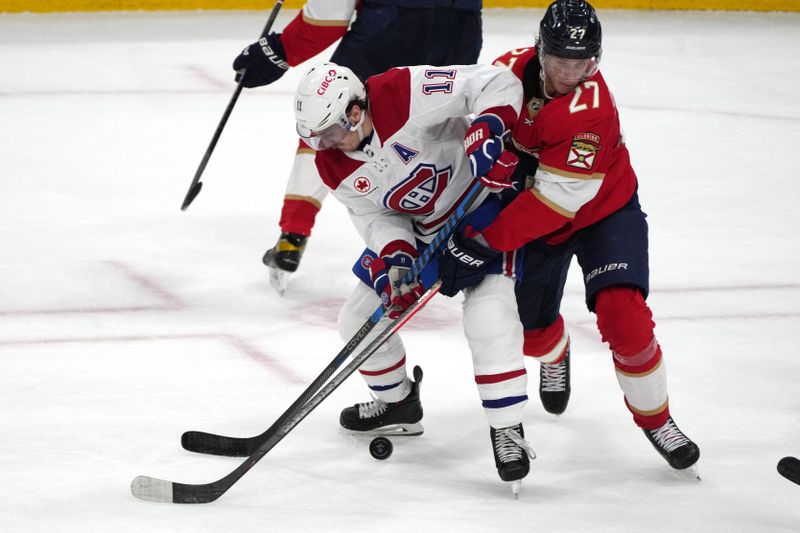 Dec 30, 2023; Sunrise, Florida, USA;  Montreal Canadiens right wing Brendan Gallagher (11) battles for possession against Florida Panthers center Eetu Luostarinen (27) during the third period at Amerant Bank Arena. Mandatory Credit: Jim Rassol-USA TODAY Sports