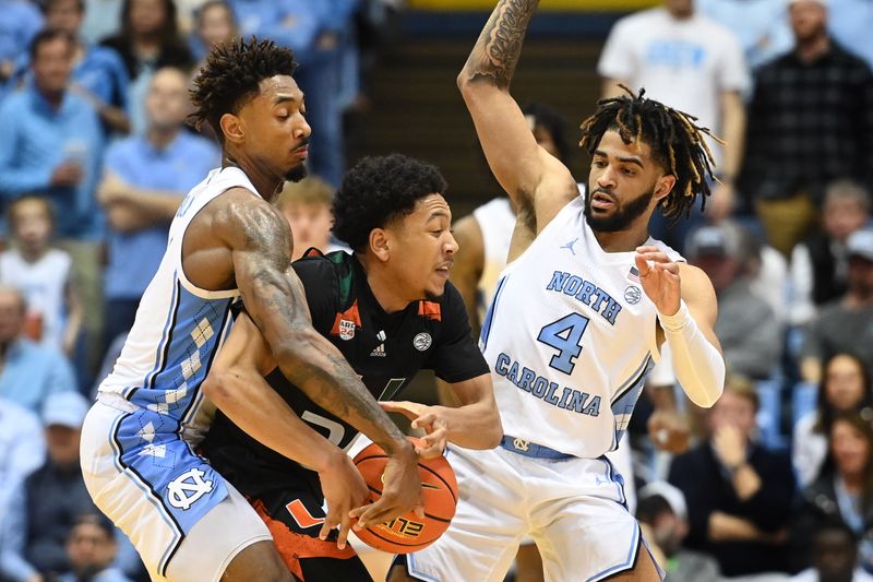 Feb 13, 2023; Chapel Hill, North Carolina, USA; Miami (Fl) Hurricanes guard Nijel Pack (24) with the ball as North Carolina Tar Heels forward Leaky Black (1) and guard R.J. Davis (4) pressure in the second half at Dean E. Smith Center. Mandatory Credit: Bob Donnan-USA TODAY Sports