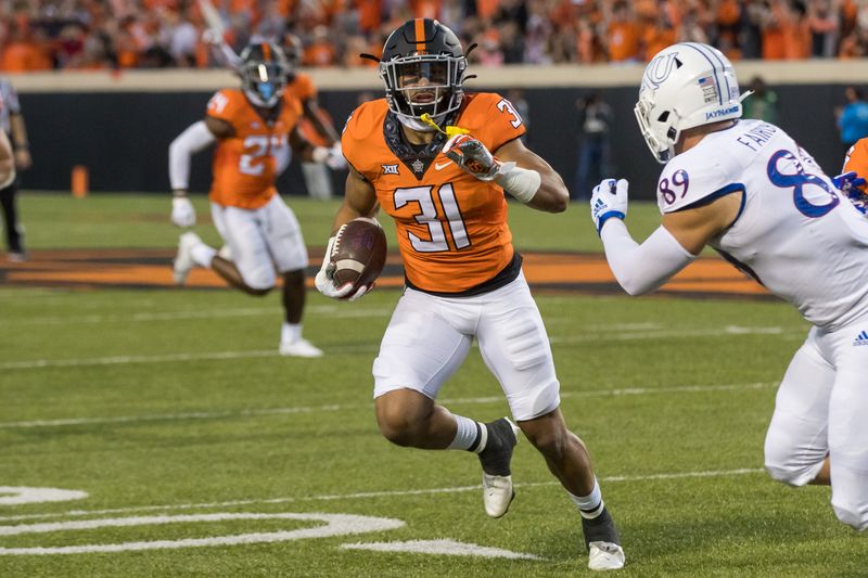 Oct 30, 2021; Stillwater, Oklahoma, USA;  Oklahoma State Cowboys safety Kolby Harvell-Peel (31) returns an interception as Kansas Jayhawks tight end Mason Fairchild (89) closes in for the tackle during the first quarter at Boone Pickens Stadium. Mandatory Credit: Brett Rojo-USA TODAY Sports