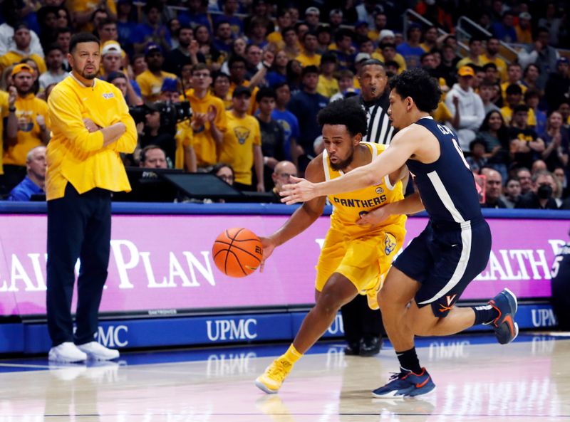 Jan 3, 2023; Pittsburgh, Pennsylvania, USA; Pittsburgh Panthers guard Nelly Cummings (0) drives to the basket against Virginia Cavaliers guard Kihei Clark (right) during the second half at the Petersen Events Center. Pittsburgh won 68-65. Mandatory Credit: Charles LeClaire-USA TODAY Sports