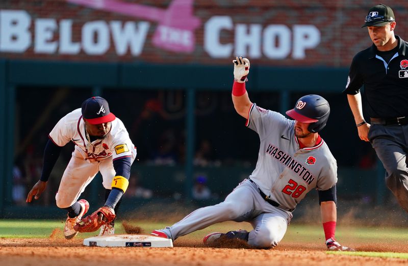 May 27, 2024; Cumberland, Georgia, USA; Washington Nationals outfielder Lane Thomas (28) slides in safely at second base against Atlanta Braves second baseman Ozzie Albies (1) during the eighth inning against the Washington Nationals at Truist Park. Mandatory Credit: John David Mercer-USA TODAY Sports