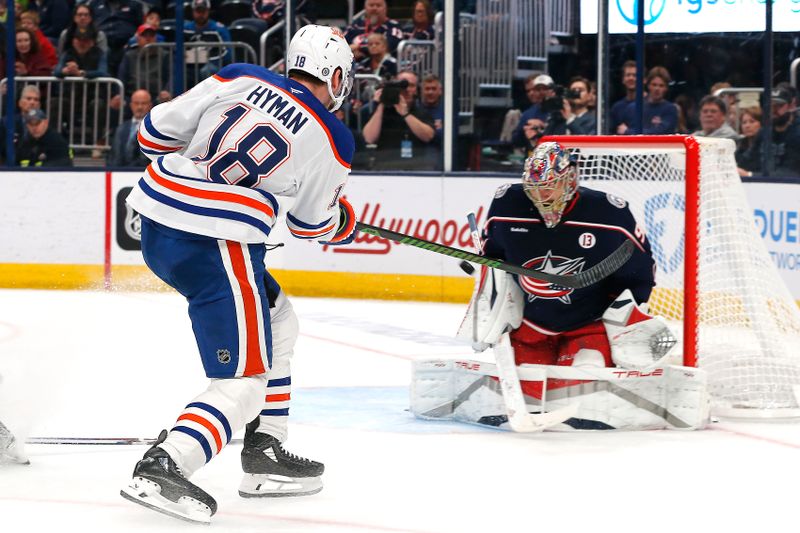 Oct 28, 2024; Columbus, Ohio, USA; Edmonton Oilers center Zach Hyman (18) shoots as Columbus Blue Jackets goalie Elvis Merzlikins (90) makes a save during the first period at Nationwide Arena. Mandatory Credit: Russell LaBounty-Imagn Images