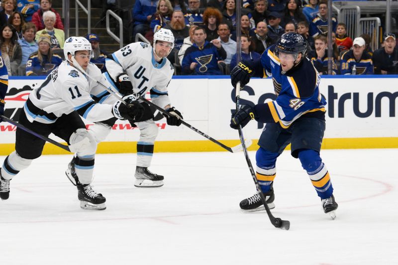 Nov 7, 2024; St. Louis, Missouri, USA; Utah Hockey Club right wing Dylan Guenther (11) defends a shot from St. Louis Blues defenseman Scott Perunovich (48) during the second period at Enterprise Center. Mandatory Credit: Jeff Le-Imagn Images