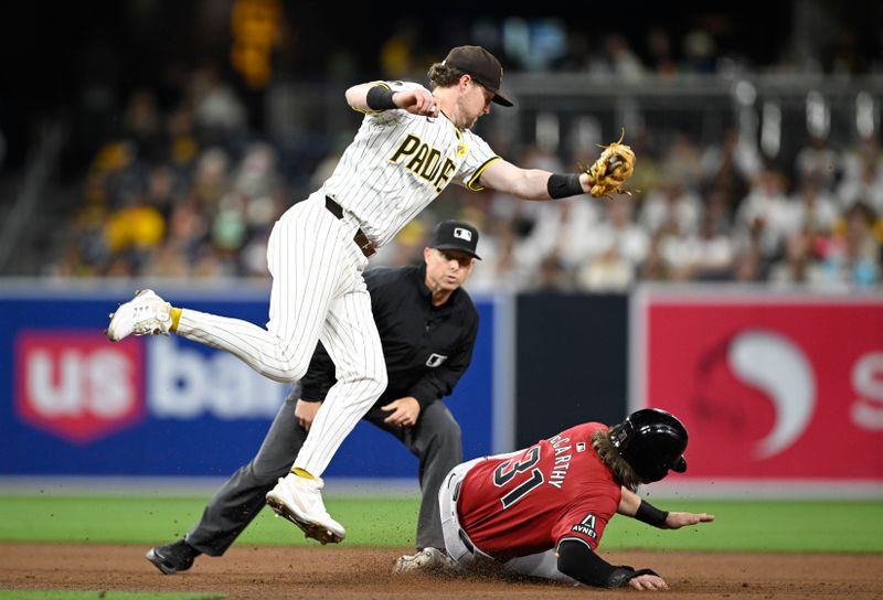 Jun 6, 2024; San Diego, California, USA; San Diego Padres first baseman Jake Cronenworth (9) fields a high throw as Arizona Diamondbacks right fielder Jake McCarthy (31) steals second base during the eighth inning at Petco Park. Mandatory Credit: Denis Poroy-USA TODAY Sports at Petco Park. 