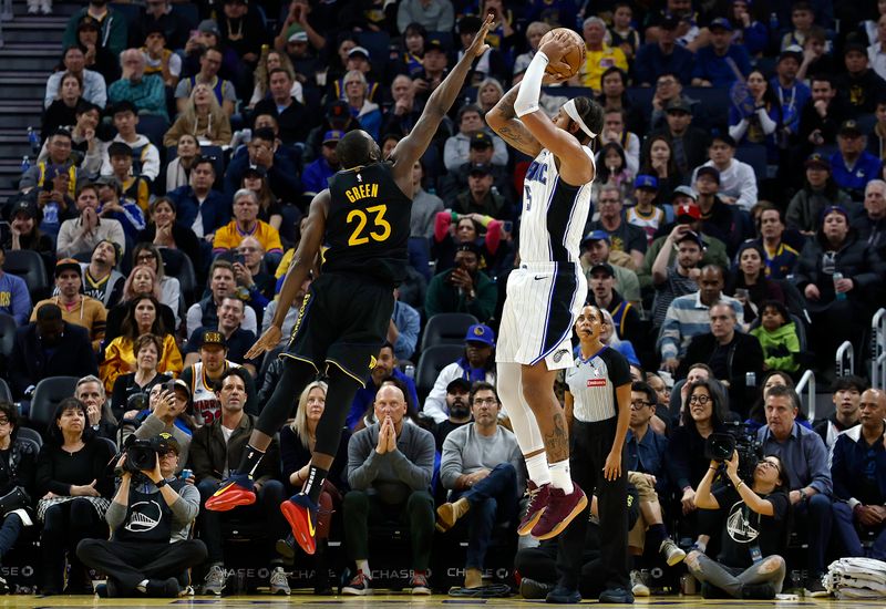 SAN FRANCISCO, CALIFORNIA - FEBRUARY 03: Paolo Banchero #5 of the Orlando Magic shoots over Draymond Green #23 of the Golden State Warriors during the second half of an NBA basketball game at Chase Center on February 03, 2025 in San Francisco, California. NOTE TO USER: User expressly acknowledges and agrees that, by downloading and or using this photograph, User is consenting to the terms and conditions of the Getty Images License Agreement.  (Photo by Thearon W. Henderson/Getty Images)