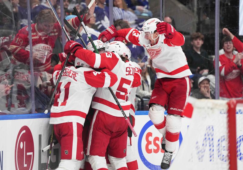 Apr 13, 2024; Toronto, Ontario, CAN; Detroit Red Wings defenseman Moritz Seider (53) celebrates the win with defenseman Shayne Gostisbehere (41) against the Toronto Maple Leafs during the overtime period at Scotiabank Arena. Mandatory Credit: Nick Turchiaro-USA TODAY Sports