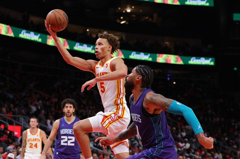 ATLANTA, GEORGIA - OCTOBER 25:  Dyson Daniels #5 of the Atlanta Hawks drives against Nick Richards #4 of the Charlotte Hornets during the fourth quarter at State Farm Arena on October 25, 2024 in Atlanta, Georgia.  NOTE TO USER: User expressly acknowledges and agrees that, by downloading and/or using this photograph, user is consenting to the terms and conditions of the Getty Images License Agreement.  (Photo by Kevin C. Cox/Getty Images)