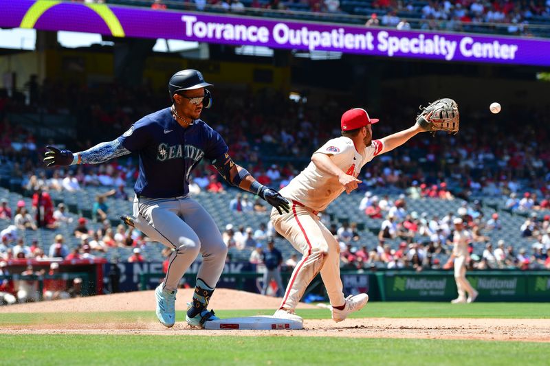 Jul 14, 2024; Anaheim, California, USA; Seattle Mariners center fielder Julio Rodriguez (44) beats the throw to first ahead of Los Angeles Angels first baseman Nolan Schanuel (18) during the sixth inning at Angel Stadium. Mandatory Credit: Gary A. Vasquez-USA TODAY Sports