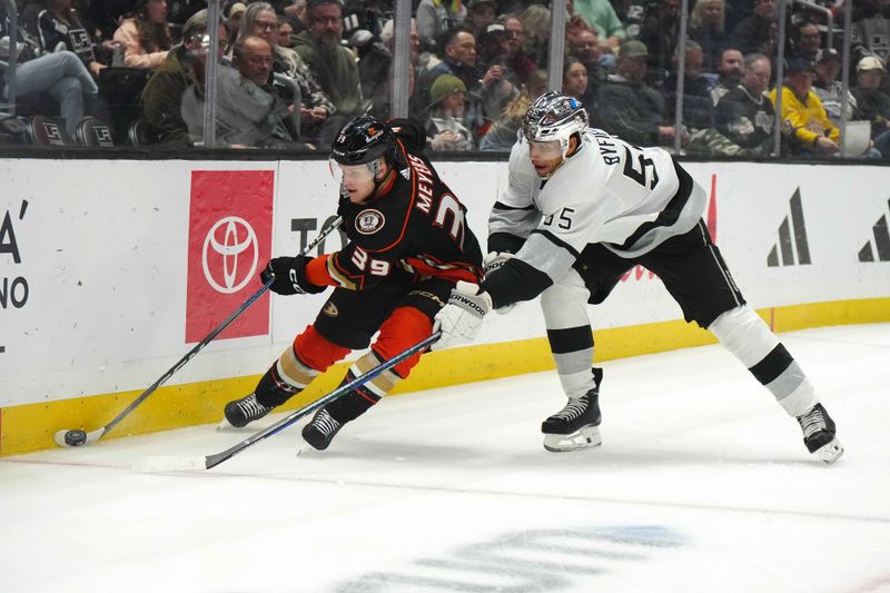 Apr 13, 2024; Los Angeles, California, USA; Anaheim Ducks center Ben Meyers (39) and LA Kings right wing Quinton Byfield (55) reach for the puck in the first period at Crypto.com Arena. Mandatory Credit: Kirby Lee-USA TODAY Sports