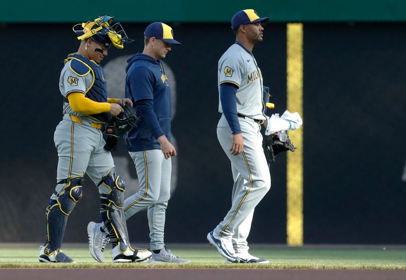 Apr 22, 2024; Pittsburgh, Pennsylvania, USA;  Milwaukee Brewers catcher William Contreras (24), pitching coach Chris Hook (middle) and starting pitcher Joe Ross (right) make their way in from the bullpen to play the Pittsburgh Pirates at PNC Park. Mandatory Credit: Charles LeClaire-USA TODAY Sports