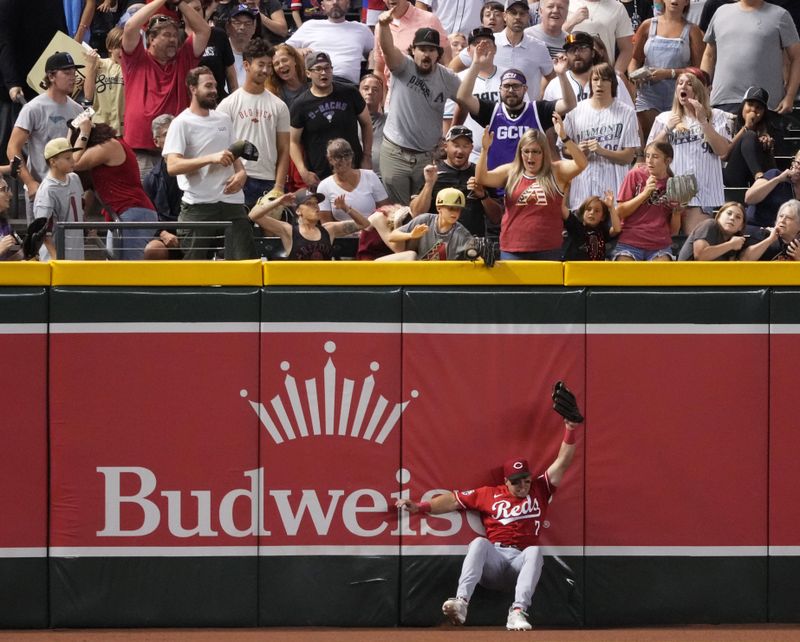 Aug 25, 2023; Phoenix, Arizona, USA; Cincinnati Reds left fielder Spencer Steer (7) is unable to make a catch on a ball hit by Arizona Diamondbacks left fielder Tommy Pham (not pictured) as a fan interferes with the play during the seventh inning at Chase Field. The home run was overturned due to fan interference. Mandatory Credit: Joe Camporeale-USA TODAY Sports