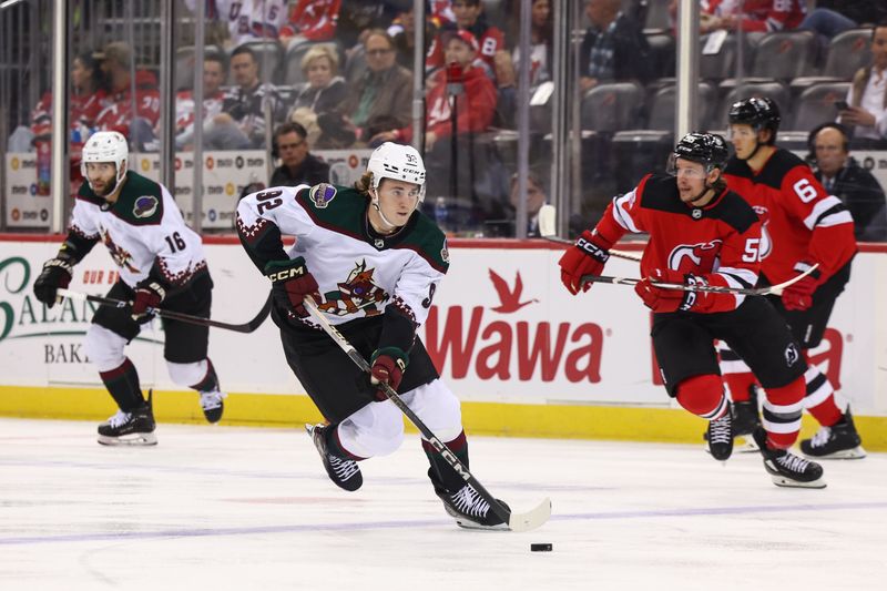 Oct 13, 2023; Newark, New Jersey, USA; Arizona Coyotes center Logan Cooley (92) skates with the puck against the New Jersey Devils during the first period at Prudential Center. Mandatory Credit: Ed Mulholland-USA TODAY Sports