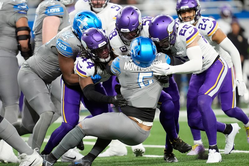 Detroit Lions running back David Montgomery (5) is stopped by Minnesota Vikings safety Harrison Smith (22) during the first half of an NFL football game, Sunday, Jan. 7, 2024, in Detroit. (AP Photo/Paul Sancya)