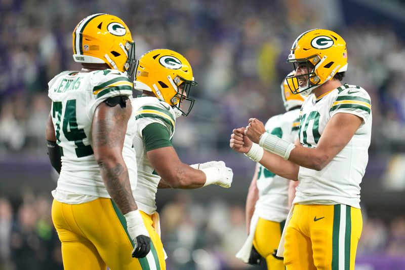 Green Bay Packers' Jordan Love celebrates his touchdown run with teamates during the first half of an NFL football game against the Minnesota Vikings Sunday, Dec. 31, 2023, in Minneapolis. (AP Photo/Abbie Parr)