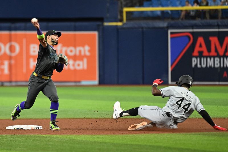 May 7, 2024; St. Petersburg, Florida, USA; Tampa Bay Rays shortstop Jose Caballero (7) throws to first base as Chicago White Sox third baseman Bryan Ramos (44) slides in the ninth inning at Tropicana Field. Mandatory Credit: Jonathan Dyer-USA TODAY Sports