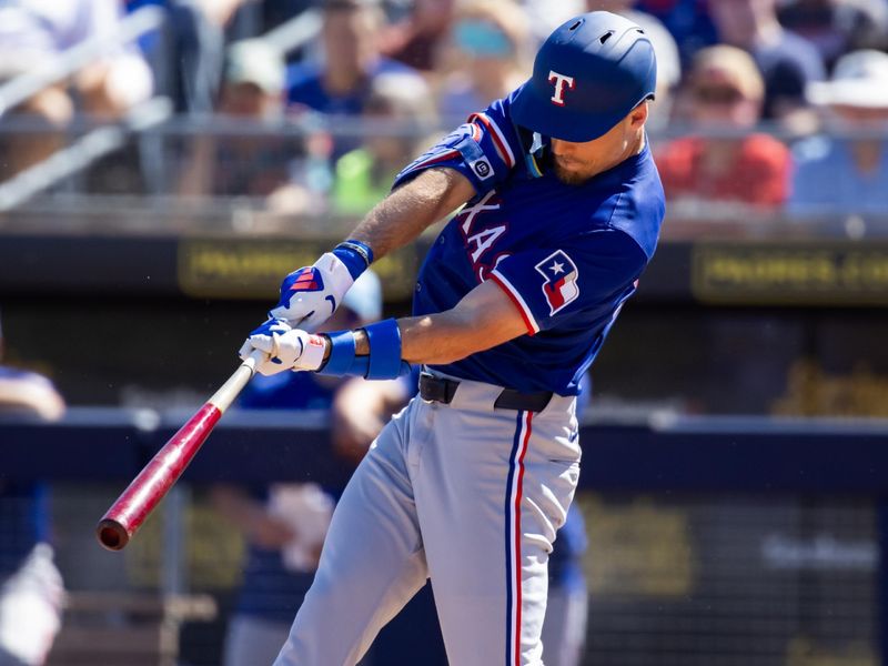 Mar 5, 2024; Peoria, Arizona, USA; Texas Rangers outfielder Evan Carter hits a home run against the Seattle Mariners during a spring training baseball game at Peoria Sports Complex. Mandatory Credit: Mark J. Rebilas-USA TODAY Sports