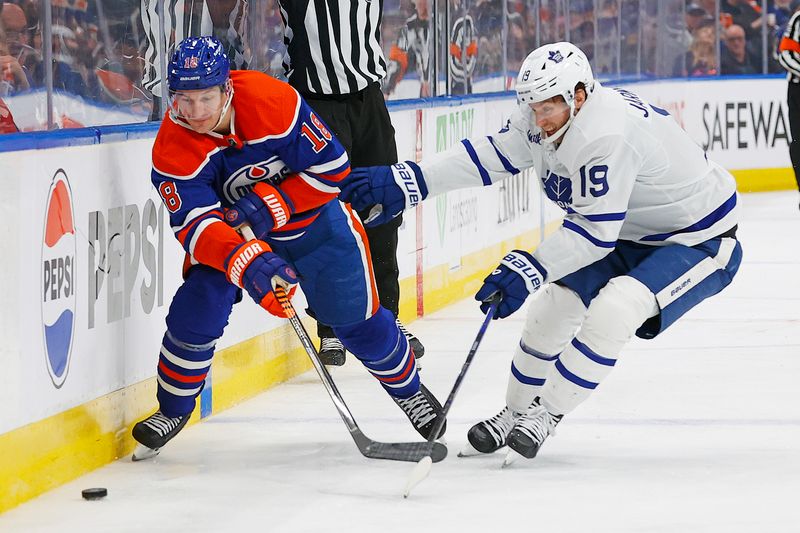 Jan 16, 2024; Edmonton, Alberta, CAN; Edmonton Oilers forward Zach Hyman (18) and Toronto Maple Leafs forward Calle Jarnkrok (19) Battle along the boards for a loose puck during the third period at Rogers Place. Mandatory Credit: Perry Nelson-USA TODAY Sports