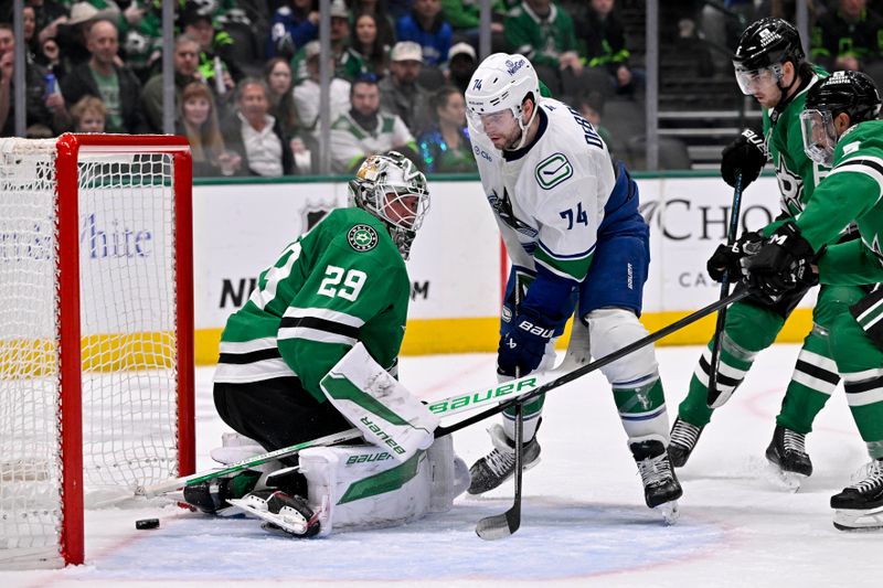 Jan 31, 2025; Dallas, Texas, USA; Vancouver Canucks left wing Jake DeBrusk (74) scores a power play goal against Dallas Stars goaltender Jake Oettinger (29) during the third period at the American Airlines Center. Mandatory Credit: Jerome Miron-Imagn Images