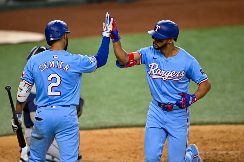 Sep 22, 2024; Arlington, Texas, USA; Texas Rangers third baseman Ezequiel Duran (20) and second baseman Marcus Semien (2) celebrate after Duran hits a home run against the Seattle Mariners during the seventh inning at Globe Life Field. Mandatory Credit: Jerome Miron-Imagn Images