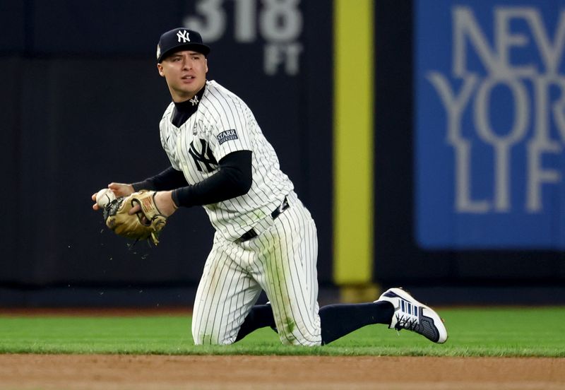 Oct 30, 2024; New York, New York, USA; New York Yankees shortstop Anthony Volpe (11) holds the ball after an infield single during the eighth inning against the Los Angeles Dodgers in game five of the 2024 MLB World Series at Yankee Stadium. Mandatory Credit: Vincent Carchietta-Imagn Images