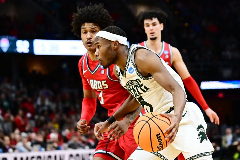 Mar 23, 2025; Cleveland, OH, USA; Michigan State Spartans guard Tre Holloman (5) dribbles the ball defended by Michigan State Spartans guard Jaden Akins (3) in the second half during the NCAA Tournament Second Round at Rocket Arena. Mandatory Credit: Ken Blaze-Imagn Images