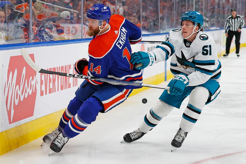 Apr 15, 2024; Edmonton, Alberta, CAN; Edmonton Oilers defensemen Mattias Ekholm (14) and San Jose Sharks forward Collin Graf (51) battle along the boards for a loose puck during the second period at Rogers Place. Mandatory Credit: Perry Nelson-USA TODAY Sports