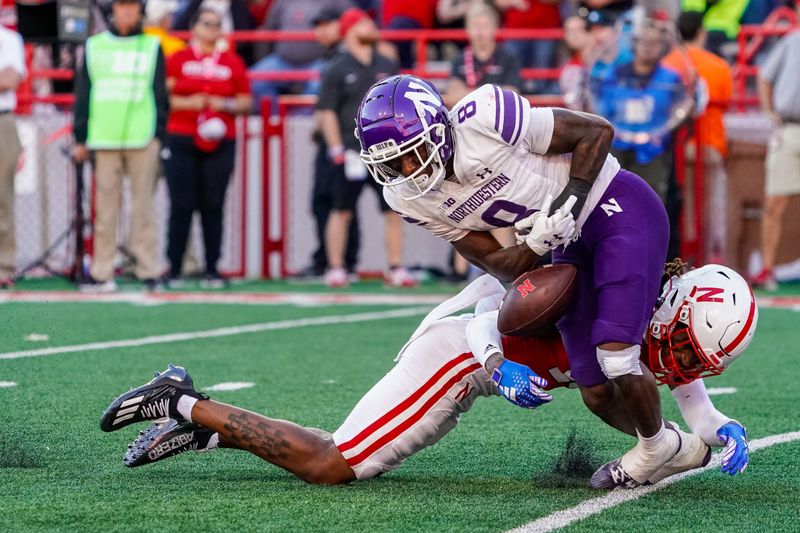 Oct 21, 2023; Lincoln, Nebraska, USA; Northwestern Wildcats wide receiver A.J. Henning (8) is tackled by Nebraska Cornhuskers defensive back Tamon Lynum (15) during the third quarter at Memorial Stadium. Mandatory Credit: Dylan Widger-USA TODAY Sports