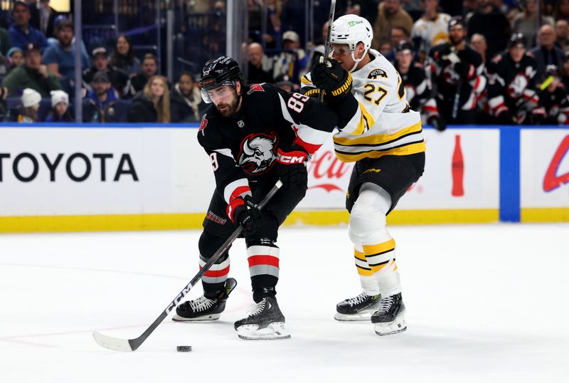 Dec 27, 2025; Buffalo, New York, USA;  Boston Bruins defenseman Hampus Lindholm (27) tries to defend as Buffalo Sabres right wing Alex Tuch (89) skates in with the puck during the second period at KeyBank Center. Mandatory Credit: Timothy T. Ludwig-Imagn Images