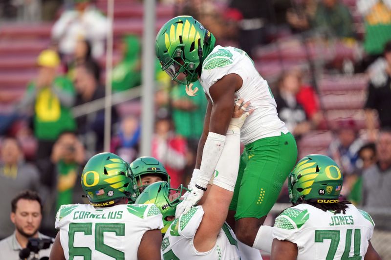 Sep 30, 2023; Stanford, California, USA; Oregon Ducks wide receiver Traeshon Holden (top) is lifted into the air by offensive lineman Jackson Powers-Johnson (center bottom) after scoring a touchdown against the Stanford Cardinal during the fourth quarter at Stanford Stadium. Mandatory Credit: Darren Yamashita-USA TODAY Sports