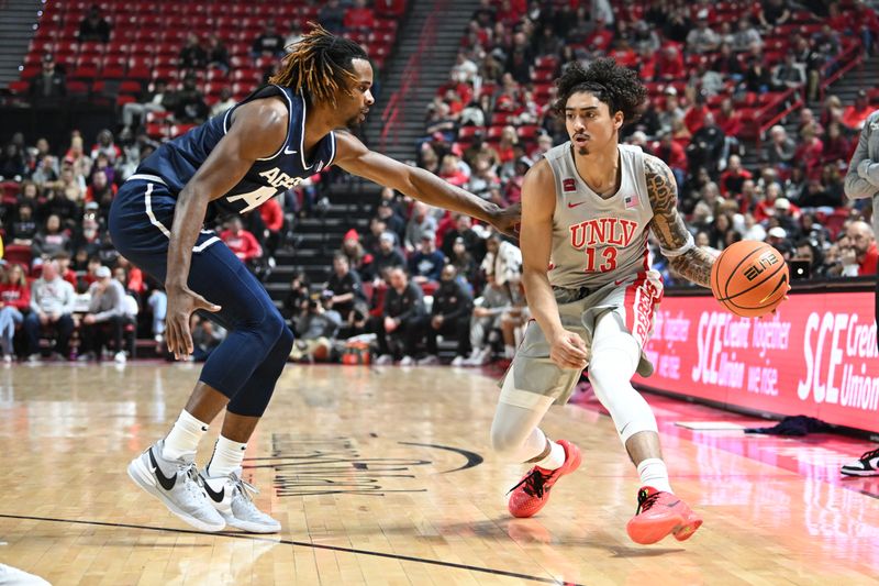 Jan 13, 2024; Las Vegas, Nevada, USA; Utah State Aggies guard Josh Uduje (14) defends against UNLV Rebels guard Brooklyn Hicks (13) in the first half at Thomas & Mack Center. Mandatory Credit: Candice Ward-USA TODAY Sports