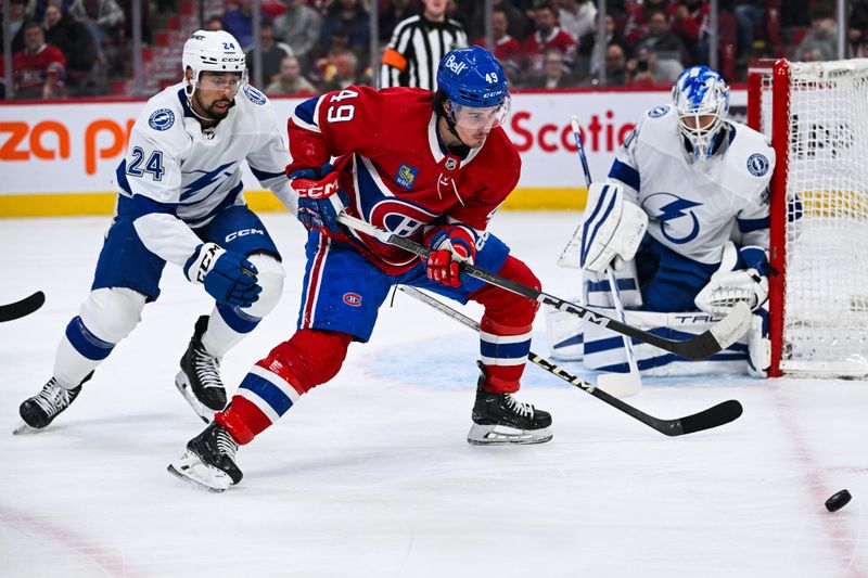 Apr 4, 2024; Montreal, Quebec, CAN; Montreal Canadiens left wing Rafael Harvey-Pinard (49) plays the puck against Tampa Bay Lightning defenseman Mathew Dumba (24) near the net during the first period at Bell Centre. Mandatory Credit: David Kirouac-USA TODAY Sports