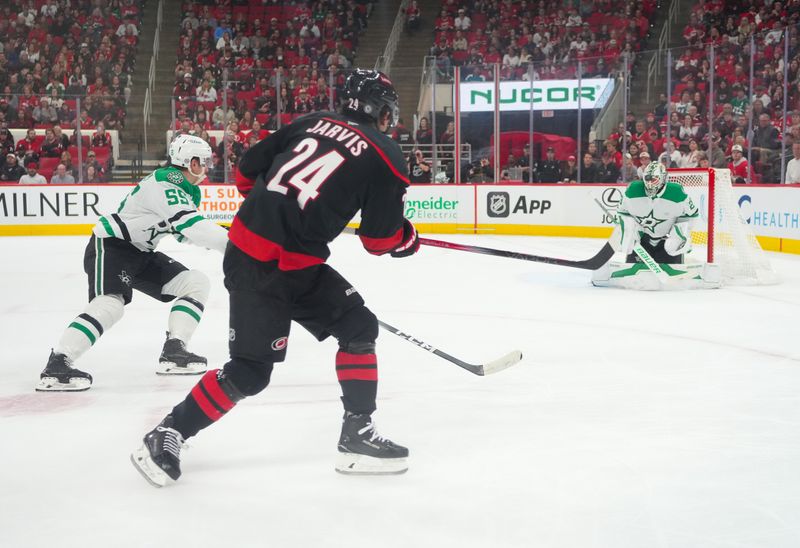 Nov 25, 2024; Raleigh, North Carolina, USA;  aCarolina Hurricanes center Seth Jarvis (24) takes a shot on Dallas Stars goaltender Jake Oettinger (29) during the third period t Lenovo Center. Mandatory Credit: James Guillory-Imagn Images