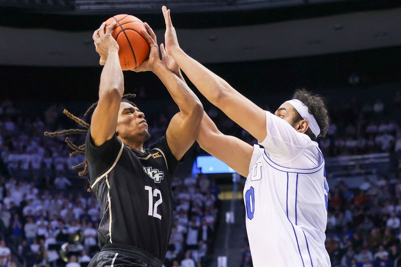 Feb 13, 2024; Provo, Utah, USA; Central Florida Knights guard DeMarr Langford Jr. (12) shoots against Brigham Young Cougars center Aly Khalifa (50) during the first half at Marriott Center. Mandatory Credit: Rob Gray-USA TODAY Sports