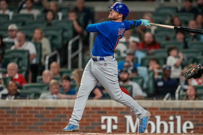 Sep 27, 2023; Cumberland, Georgia, USA; Chicago Cubs left fielder Ian Happ (8) hits a sacrifice fly ball to drive in a run against the Atlanta Braves during the tenth inning at Truist Park. Mandatory Credit: Dale Zanine-USA TODAY Sports