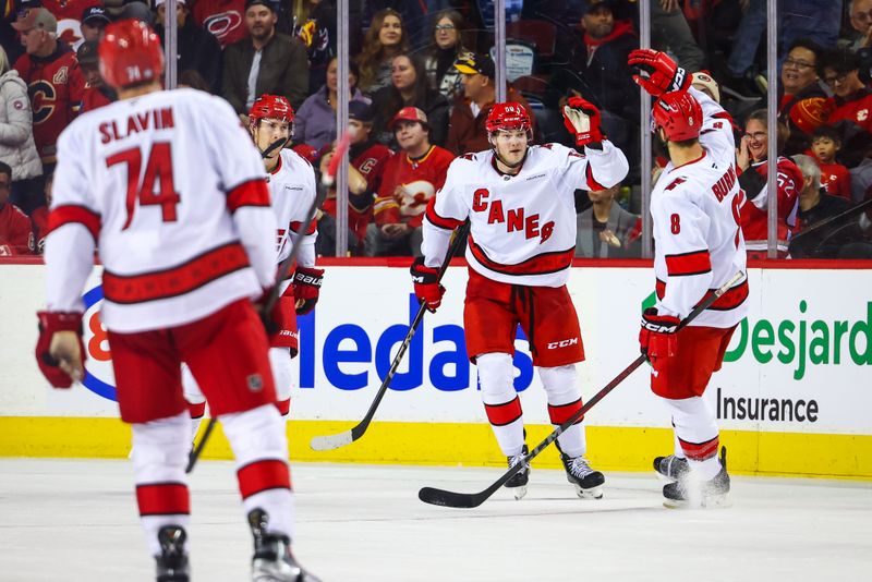 Oct 24, 2024; Calgary, Alberta, CAN; Carolina Hurricanes left wing Eric Robinson (50) celebrates his goal with teammates against the Calgary Flames during the third period at Scotiabank Saddledome. Mandatory Credit: Sergei Belski-Imagn Images