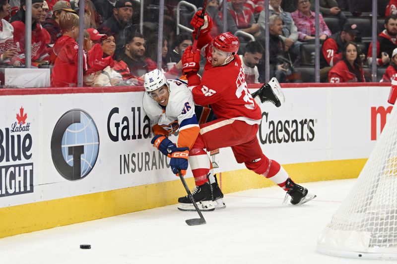 Nov 21, 2024; Detroit, Michigan, USA; Detroit Red Wings right wing Christian Fischer (36) and New York Islanders defenseman Isaiah George (36) battle for control of the puck behind the Islanders goal in the second period at Little Caesars Arena. Mandatory Credit: Lon Horwedel-Imagn Images